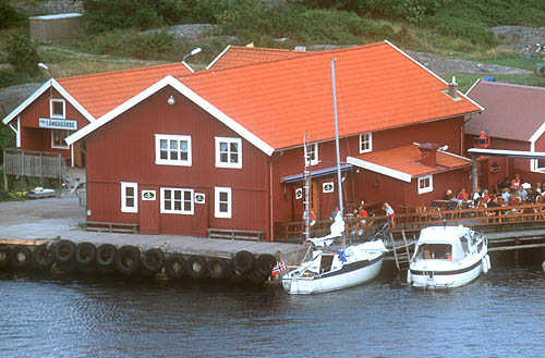 Koster museum, stor röd byggnad vid bryggan.