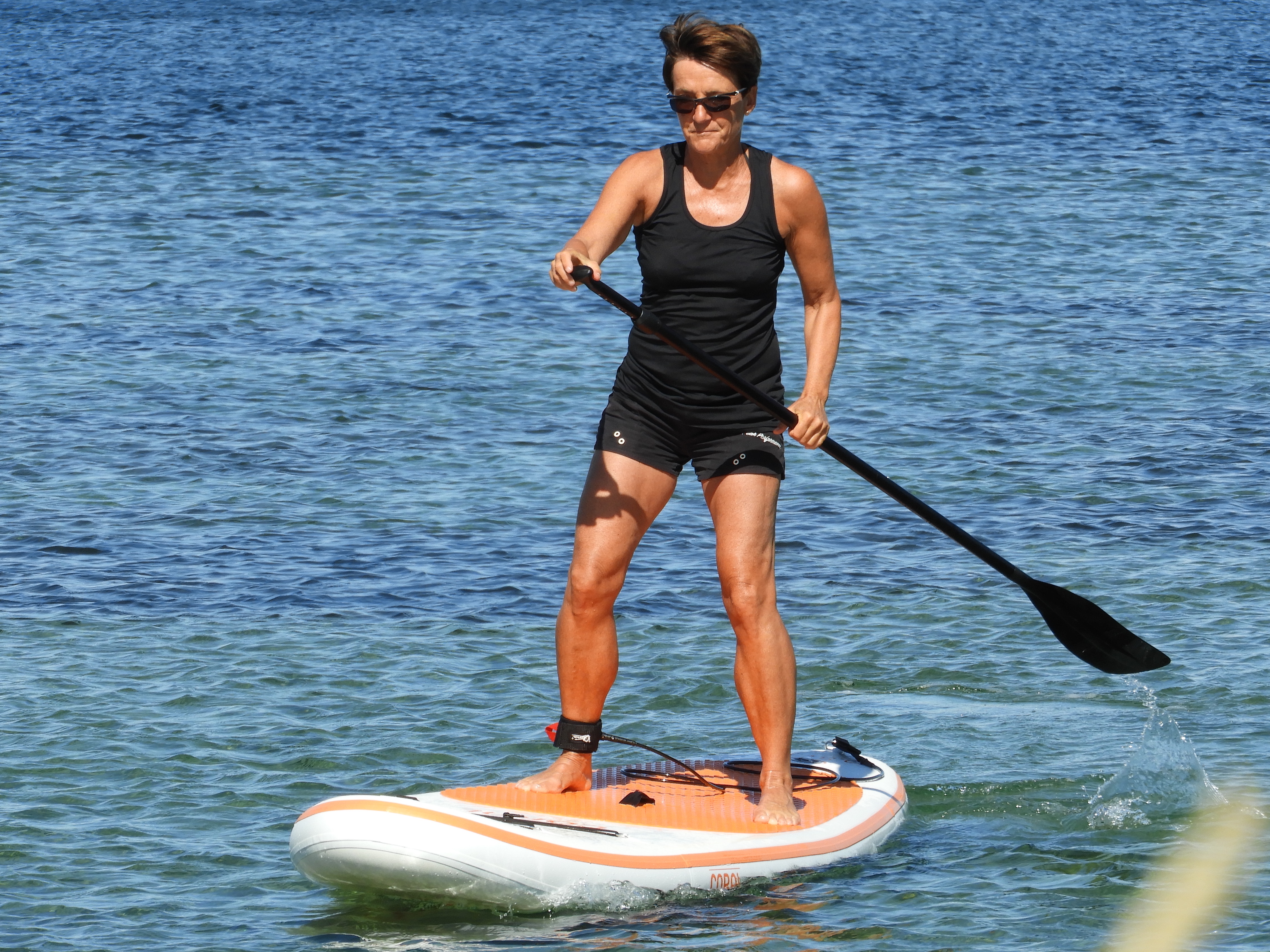 En tjej står och paddlar på en SUPbräda